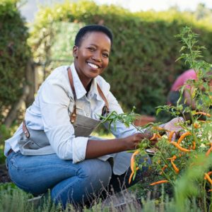 Smiling woman working in a vegetable garden.