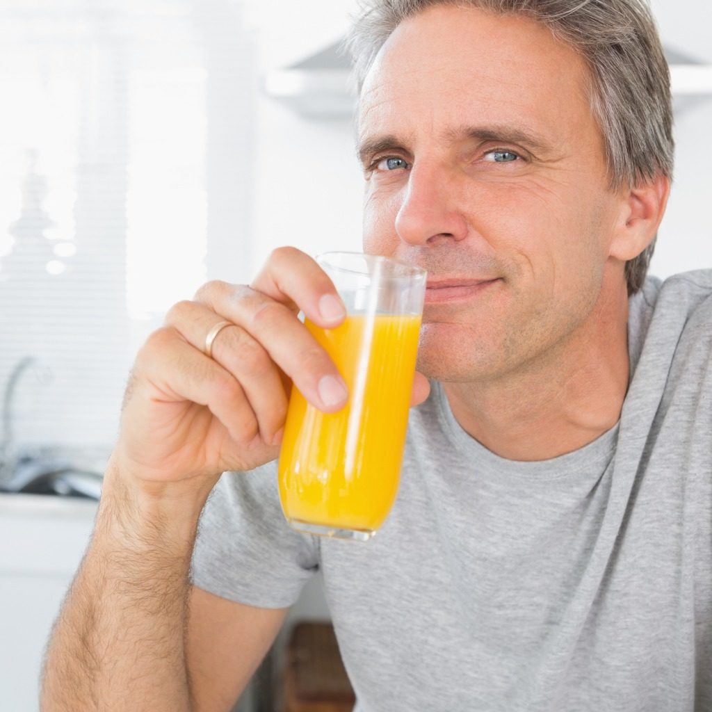 Happy Man Drinking Orange Juice In Kitchen Picture Id847368486