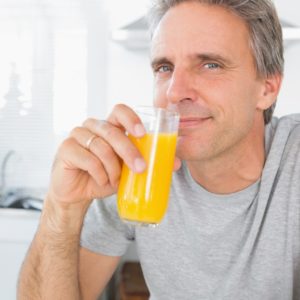 Happy Man Drinking Orange Juice for vitamin C.