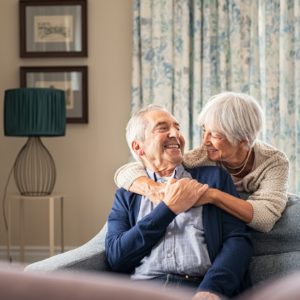 Senior Couple Hugging And smiling at home, happy with their choice to receive hormone pellet therapy.