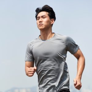 Young Asian Man Athlete Running On Beach